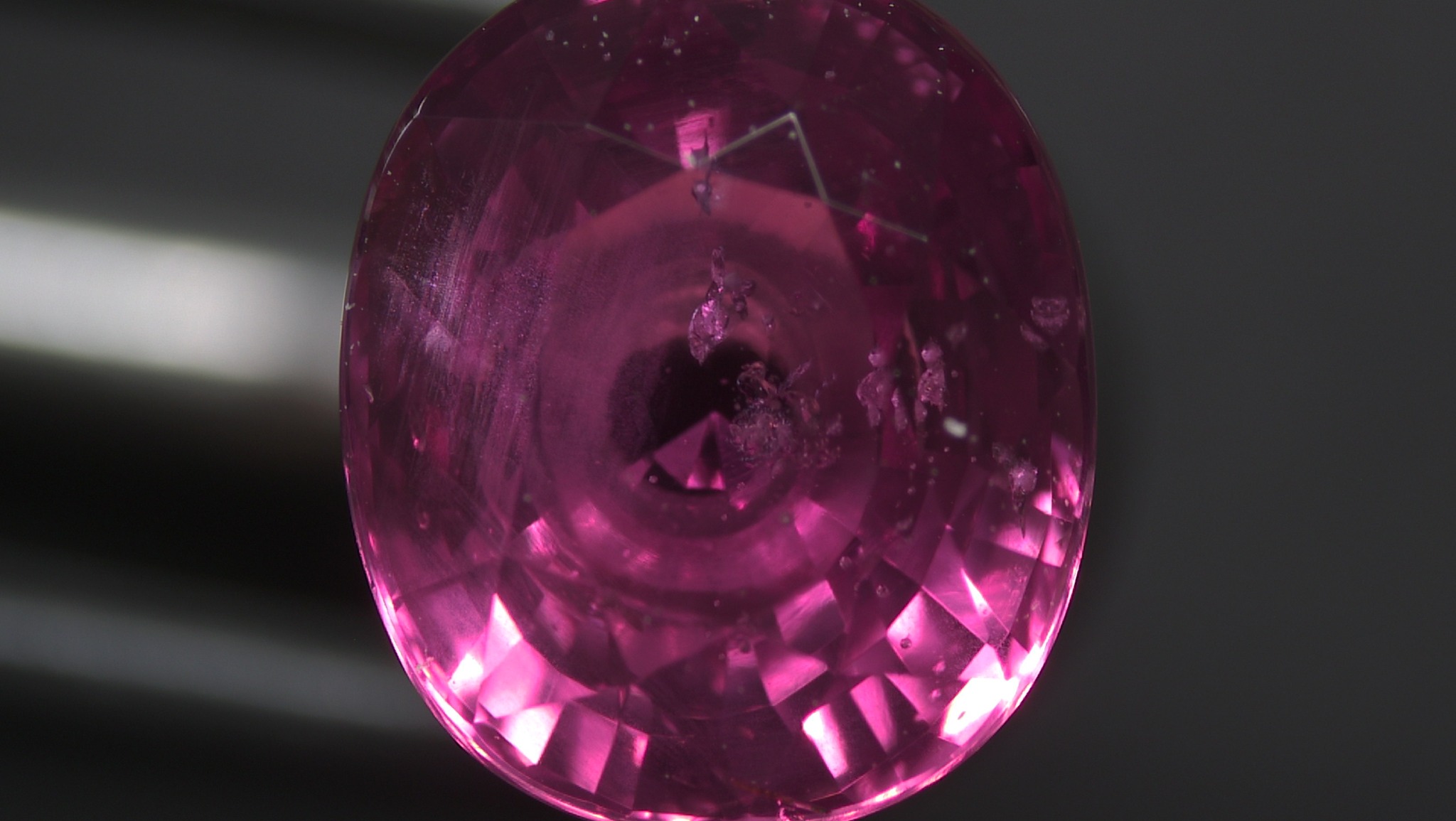 A group of small zircon crystals in an unheated purplish pink sapphire from Madagascar.